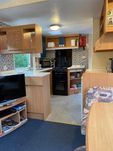 uma pequena cozinha com fogão e televisão em Forest View - Adults Only - Maximum 2 Guests em Drumnadrochit