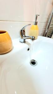 a bathroom sink with a faucet and a soap at Salford Ark Comfort Stays near Salford Royal and Trafford Centre in Manchester