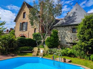 a swimming pool in front of a house at Gite Ty Nid Le 1900 in Val Couesnon