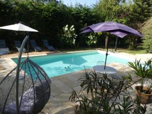 Villefranche-du-PérigordにあるLa petite aubergeのスイミングプールの隣に座ったパラソル2本