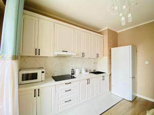 uma cozinha com armários brancos e um frigorífico branco em 125m2 new apartment, 5 rooms with airport pickup em Ulan Bator