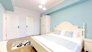 um quarto com uma cama branca e paredes azuis em 125m2 new apartment, 5 rooms with airport pickup em Ulan Bator