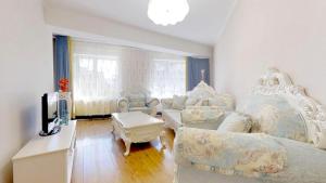 una gran sala de estar con muebles blancos y TV. en 125m2 new apartment, 5 rooms with airport pickup, en Ulán Bator