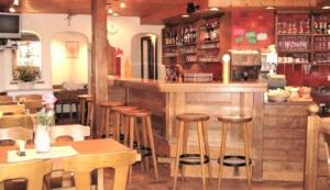 un bar en un restaurante con taburetes de madera en Hotel-Restaurant Grina en Simplon Dorf