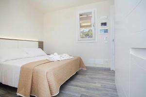 a bedroom with a bed with a blanket on it at Stabilimento Lido Burrone in Favignana
