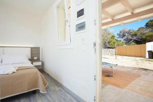 a bedroom with a bed and a window and a door at Stabilimento Lido Burrone in Favignana