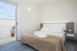 a bedroom with a large bed and a large window at Stabilimento Lido Burrone in Favignana