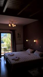 a bedroom with a large bed and a large window at Guesthouse Kastania Korakis in Kastania