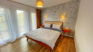 a bedroom with a bed and two windows at Sycamore Retreat Fundata in Fundata