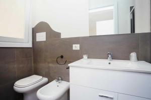 a bathroom with a sink and a toilet and a mirror at Stabilimento Lido Burrone in Favignana