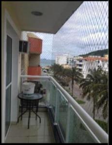un balcone con tavolo e vista sulla spiaggia di Vila del mar prainha ad Arraial do Cabo