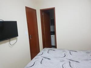 una camera da letto con un letto e una TV a schermo piatto di Vila del mar prainha ad Arraial do Cabo