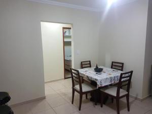una sala da pranzo con un tavolo e quattro sedie di Vila del mar prainha ad Arraial do Cabo Altre 3 foto