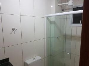 un bagno con doccia in vetro e WC di Vila del mar prainha ad Arraial do Cabo