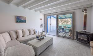 un soggiorno con divano e camino di Aquanis Anchored, sea front house, Firopotamos a Firopótamos
