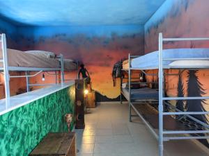 a room with two bunk beds and a mural at Rifugio Silone in Pescina