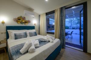 una camera da letto con un grande letto con asciugamani di Kalypso Apartments a Kalamáta
