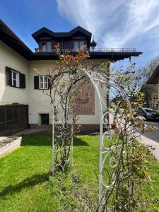 a metal arch in the grass in front of a house at Pension Sommerauer in Hallein