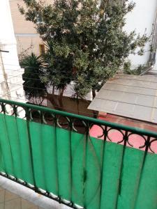 una ringhiera verde su un balcone con un albero di Flegrei Apartment a Napoli