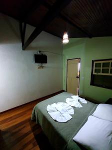 een kamer met een bed met handdoeken erop bij Pousada Bem Querer in Lavras Novas