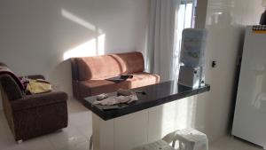 a living room with a chair and a counter at Bele vie 2 prainha in Arraial do Cabo