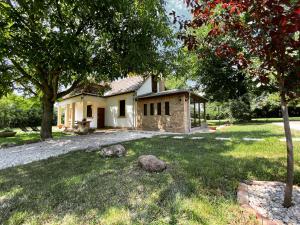 ein kleines Haus in einem Hof mit einem Baum in der Unterkunft Carpital Residence - CLASSAPART in Siófok