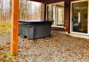 une poubelle peut s'asseoir à l'extérieur d'une maison dans l'établissement Wellness Sutton cabin #267 Rez-de-chaussée, à Sutton