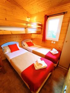 a bedroom with two beds in a log cabin at LES CHALETS DE SANCERRE in Thauvenay