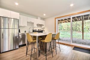 cocina con armarios blancos, mesa y sillas en Wellness Sutton cabin #267 Rez-de-chaussée en Sutton