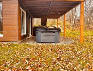 un gran cubo de basura sentado debajo de una casa en Wellness Sutton cabin #267 Rez-de-chaussée, en Sutton