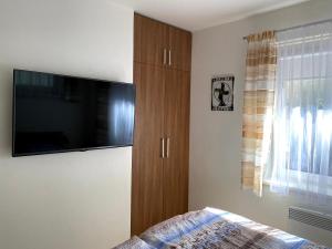 Schlafzimmer mit einem TV und einem Holzschrank in der Unterkunft Prázdninový Domek Kobylnice in Lipno nad Vltavou