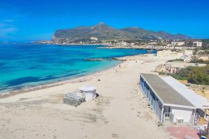 a view of a beach with a building and the ocean at Stabilimento Lido Burrone in Favignana