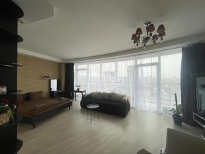 a living room with a couch and a large window at Мост Сити 7 поверх in Dnipro