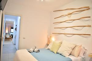 um quarto com uma cama azul com almofadas em Viuter - Magna Home las Canteras Beach + Parking em Las Palmas de Gran Canaria