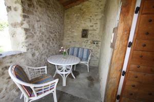 eine Terrasse mit einem Tisch und Stühlen in einem Steingebäude in der Unterkunft Touroulet in Suze
