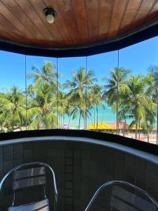 uma vista para as palmeiras a partir da janela da casa de banho em Edifício Casa Mar em Maceió