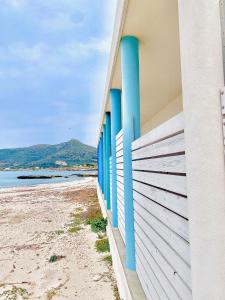 a building with blue windows on the beach at Stabilimento Lido Burrone in Favignana