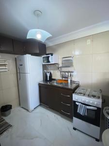 uma cozinha com um frigorífico branco e um fogão em Edifício Casa Mar em Maceió