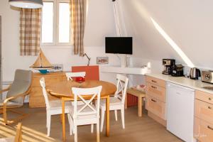 a kitchen and dining room with a table and chairs at Le COURLIS vue panoramique sur la mer, balcons in Ault
