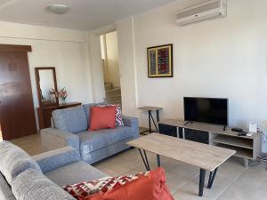 un soggiorno con divano e TV di Villas Ithaca Protaras a Protaras