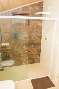 una ducha de cristal en un baño con lavabo en Suites da Lu, en Penha 32 fotos más