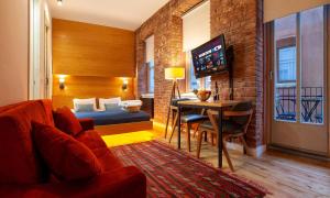 a hotel room with a bed and a table and a couch at Kumbaracı Apartments & Suites in Istanbul