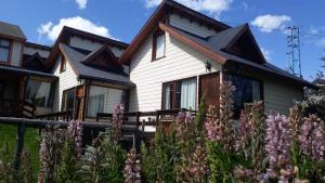 a house with flowers in front of it at La Barranca in Ushuaia +7 photos