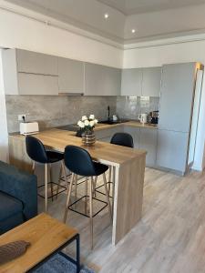 a kitchen with a wooden table and some chairs at Mirage Sea Breeze Apartment in Mamaia