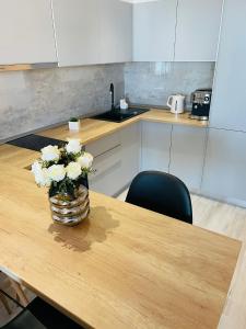 a vase of flowers on a wooden table in a kitchen at Mirage Sea Breeze Apartment in Mamaia