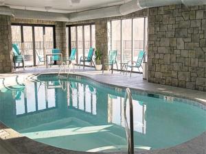a swimming pool with blue chairs and tables in a building at The Wallhouse Hotel, an Ascend Collection Hotel in Walnut Creek
