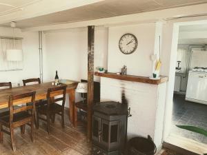 cocina con chimenea, mesa y reloj en Farmhouse near beach en Kloosterzande