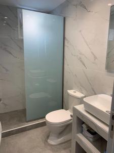 ein Badezimmer mit Toilette und Glasdusche in der Unterkunft Rhodes Comfort Luxury Apartment in Rhodos (Stadt)