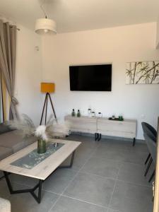 een woonkamer met een bank en een tv aan de muur bij Rhodes Comfort Luxury Apartment in Rhodos-stad