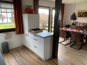 FrankenauにあるHuizeFrankenauの白いキャビネットとテーブル付きのキッチン